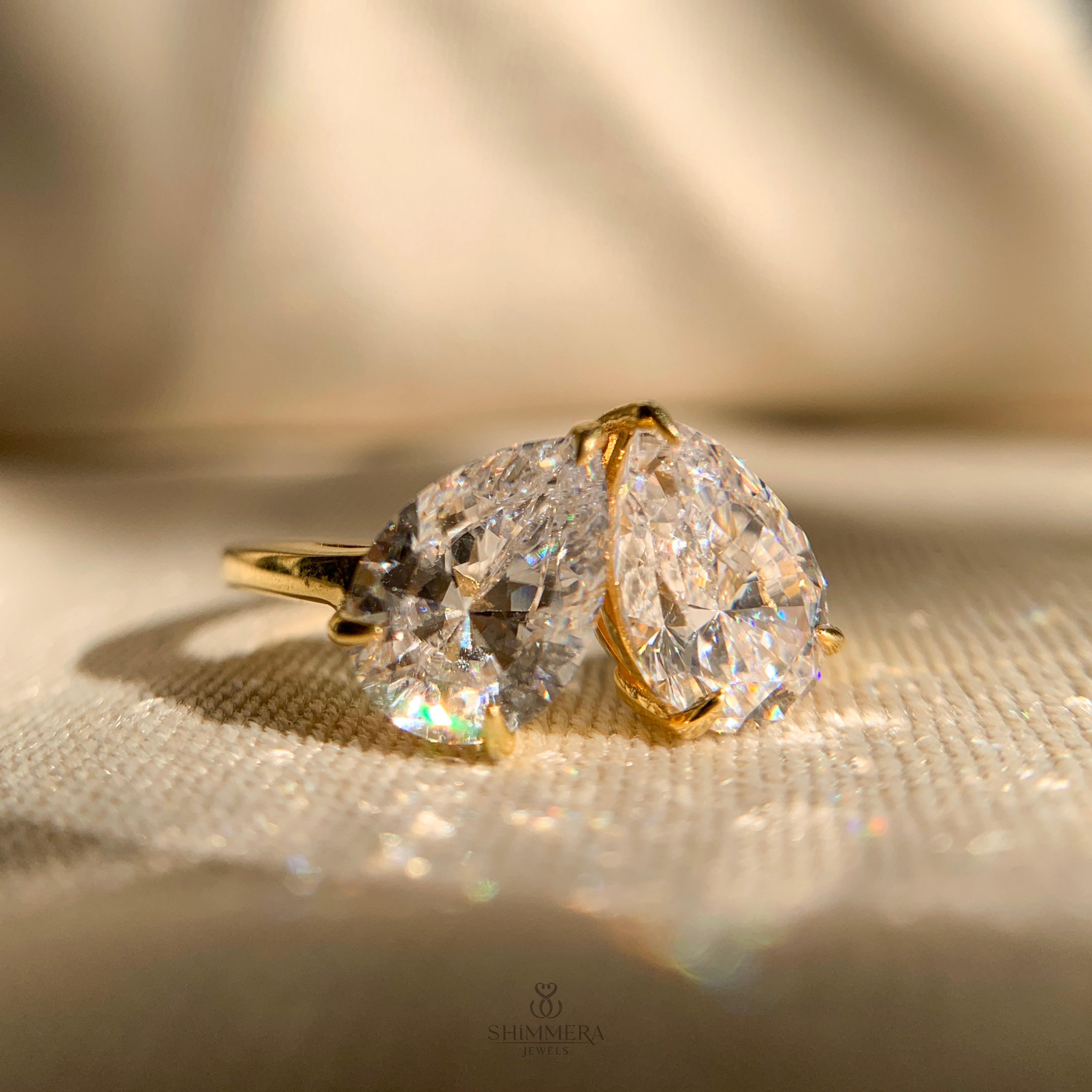 Moissanite pear cut two stone engagement ring in sleek gold band